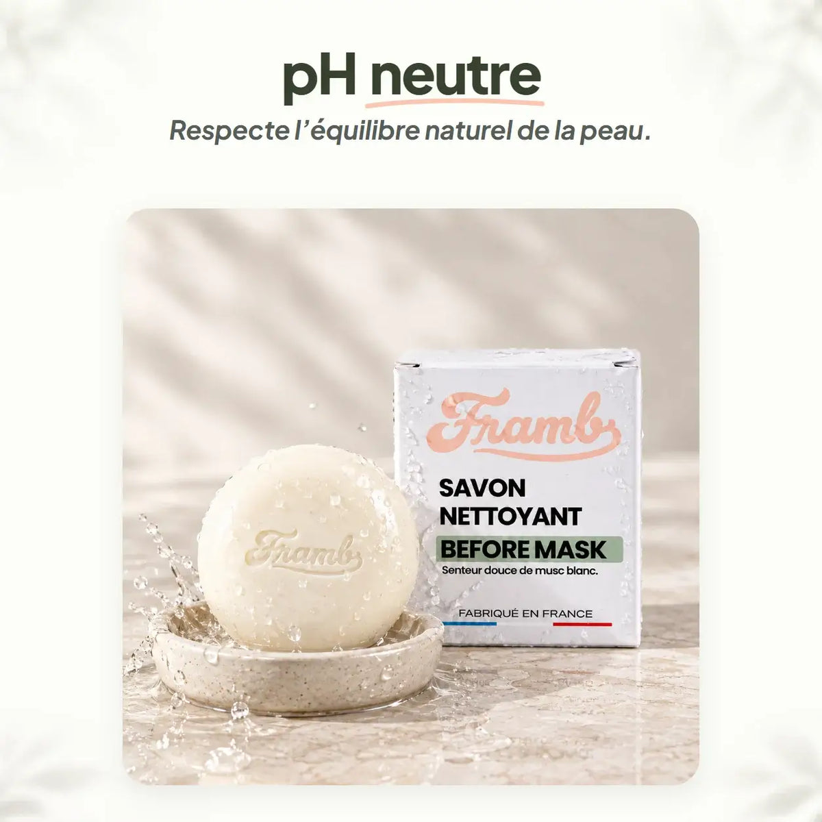 Savon anti-imperfections Framb au pH neutre, sur un porte-savon avec éclaboussures d'eau